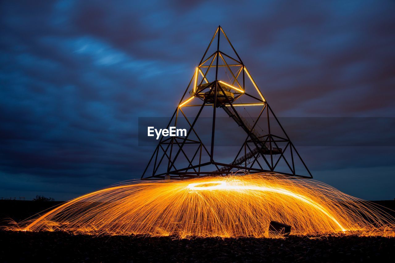 LOW ANGLE VIEW OF ILLUMINATED FERRIS WHEEL AT NIGHT