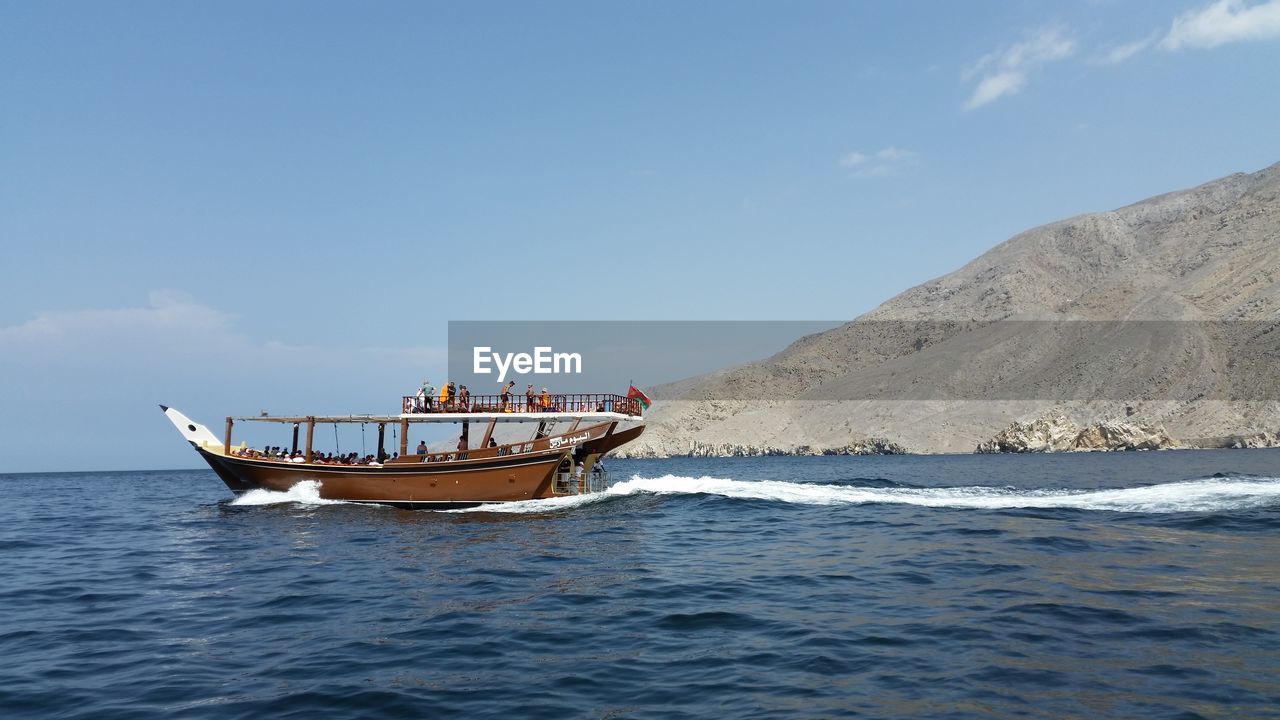 Boats in sea with mountain in background