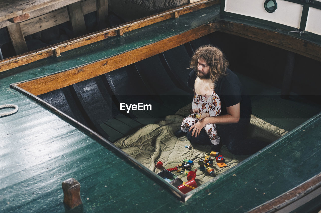 High angle view of father sitting with toddler in boat