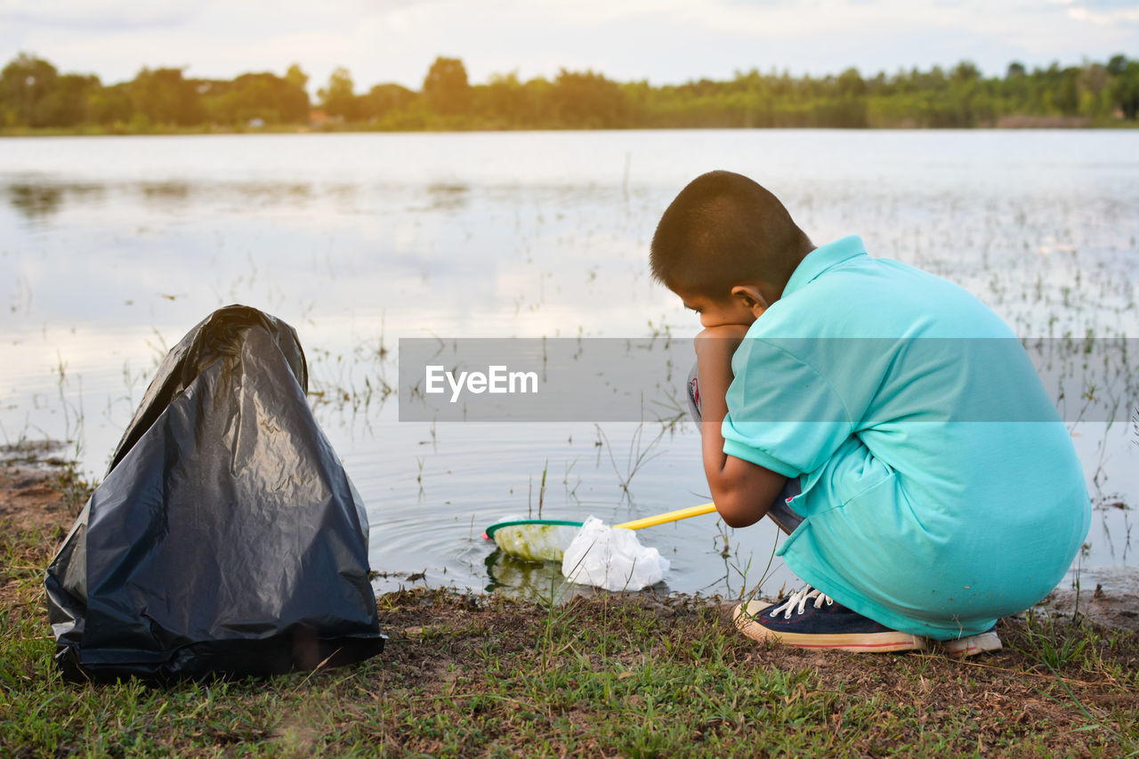 Boy with butterfly fishing net at lakeshore