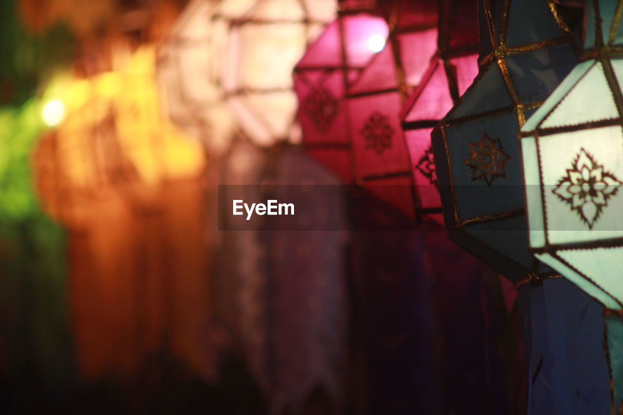 Close-up of illuminated lantern hanging against wall in building