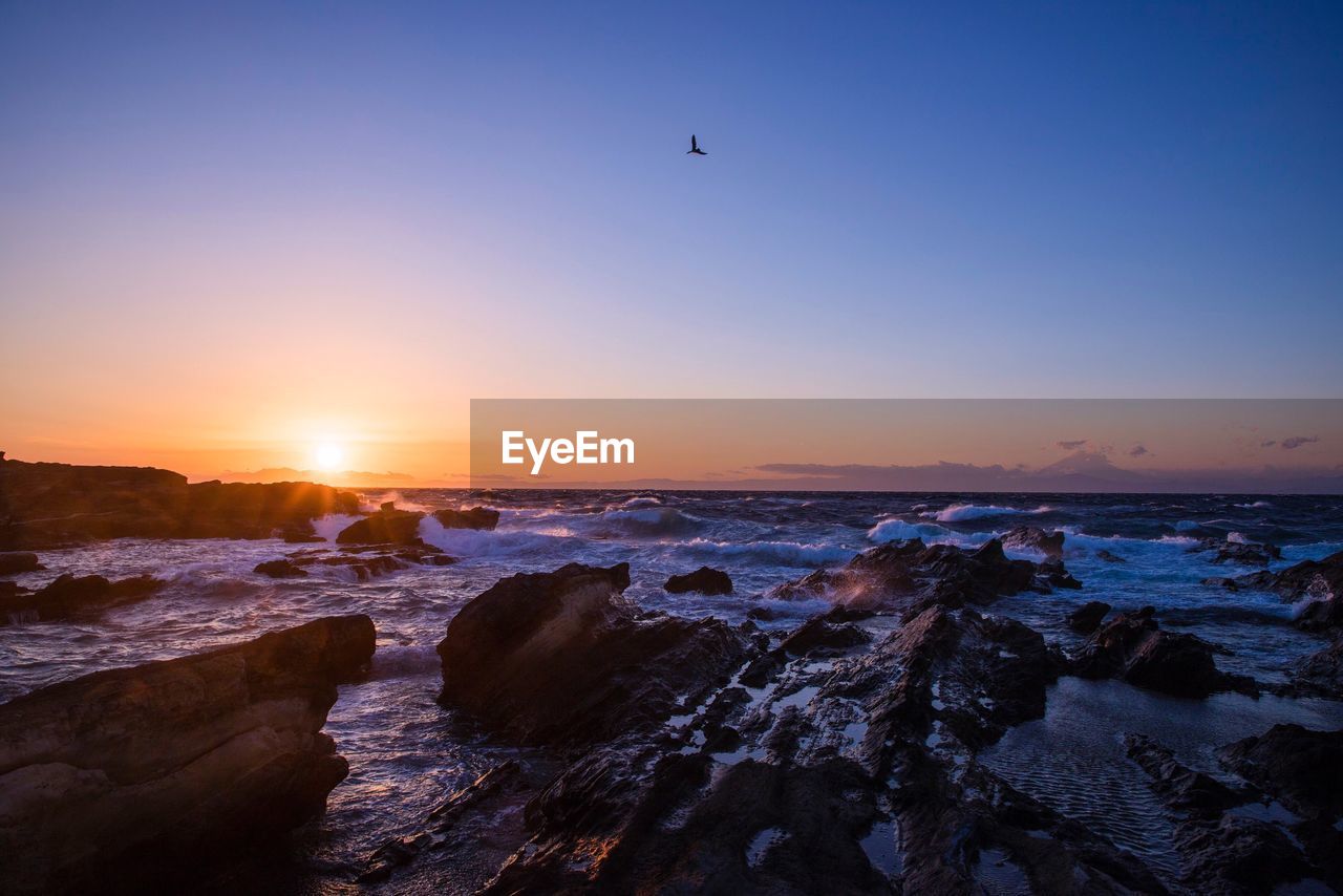 SCENIC VIEW OF SUNSET OVER SEA