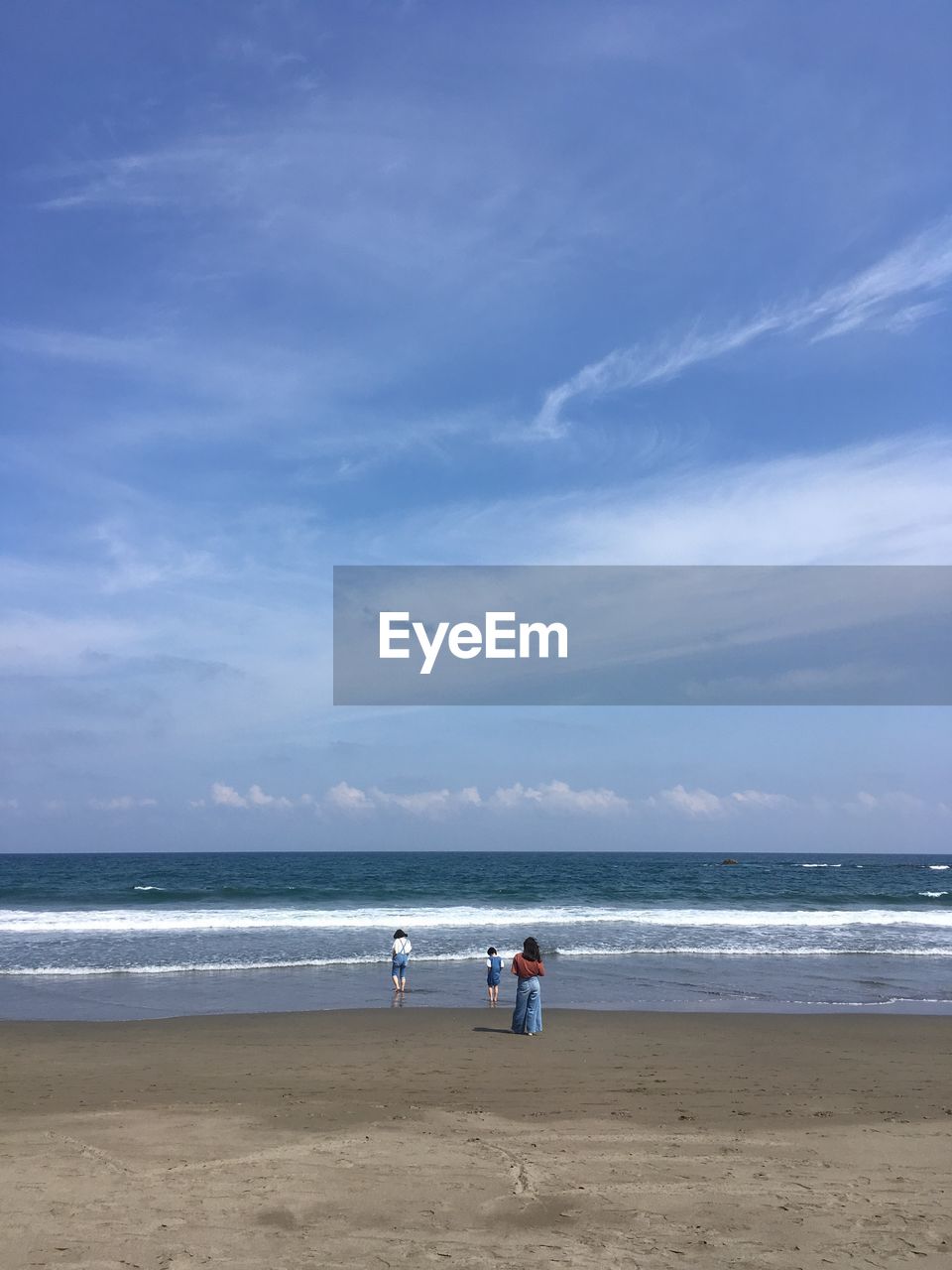 MEN ON BEACH AGAINST SKY