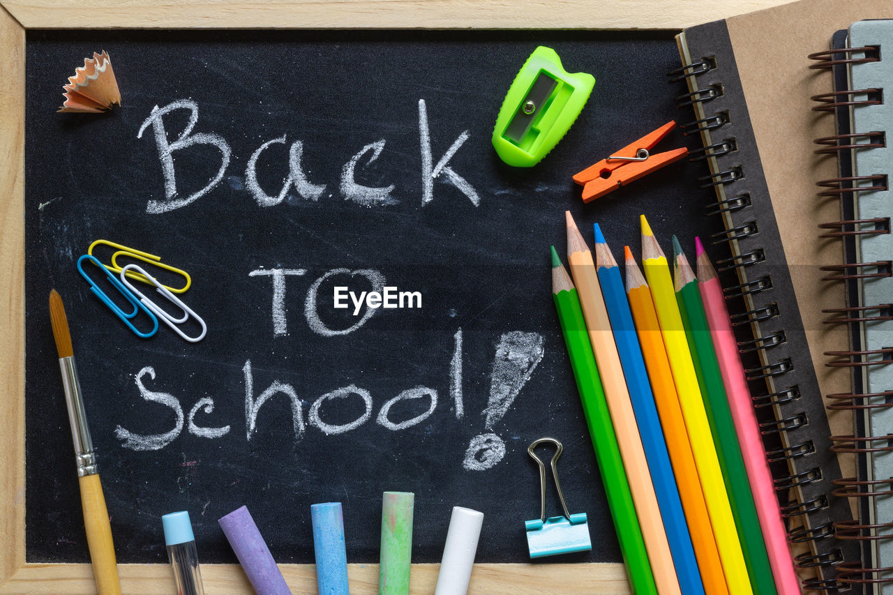 Close-up of back to school text on blackboard with school supplies