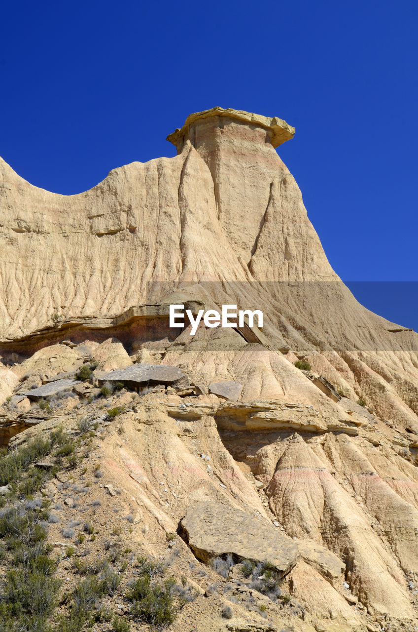 LOW ANGLE VIEW OF ROCK FORMATION AGAINST CLEAR SKY