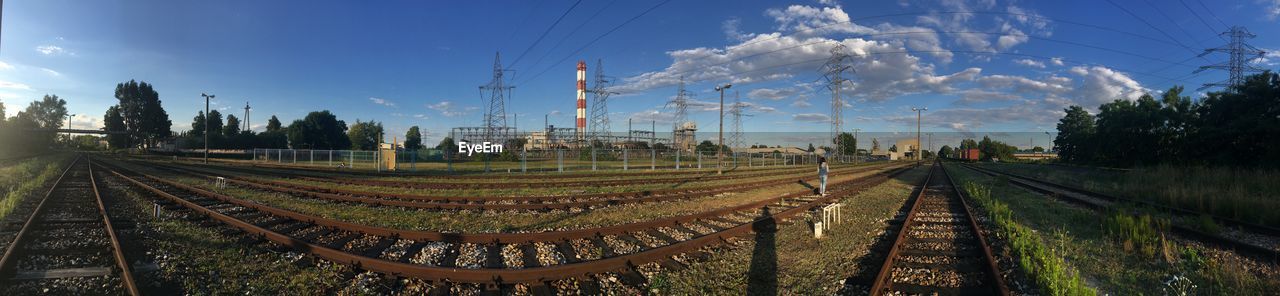 PANORAMIC SHOT OF RAILROAD TRACKS AMIDST TREES AGAINST SKY