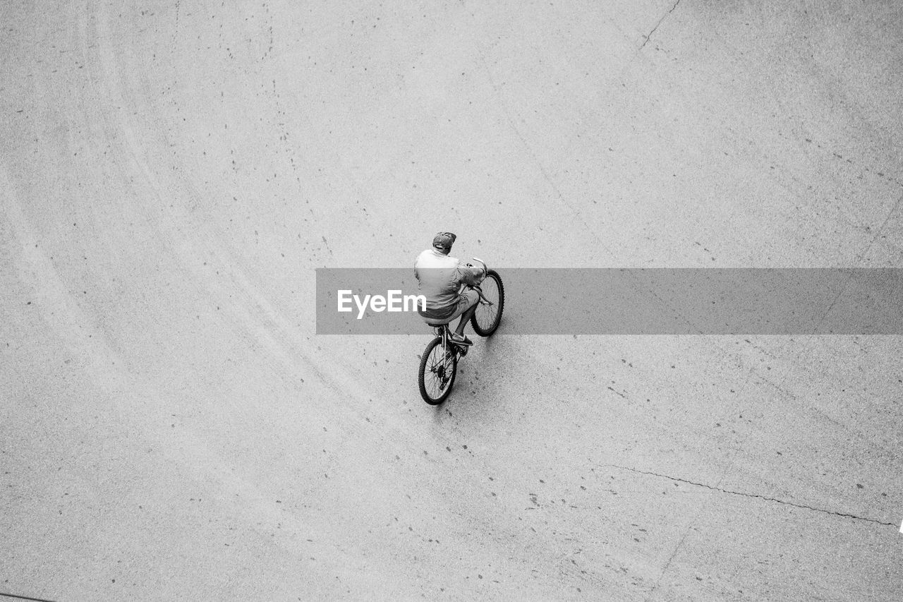 HIGH ANGLE VIEW OF PERSON RIDING BICYCLE ON MOTORCYCLE