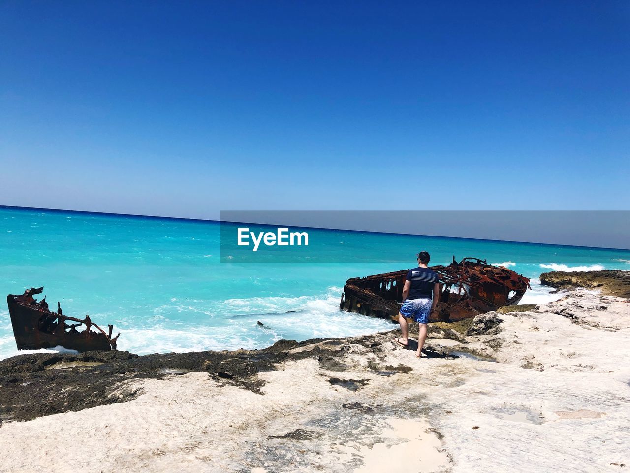 Scenic view of beach against clear blue sky