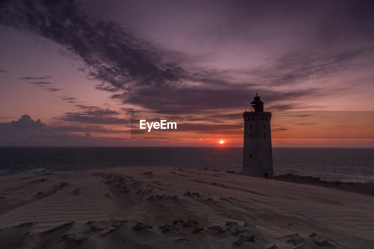 Lighthouse rubjerg knude at sunset on a stormy evening with dramatic sky