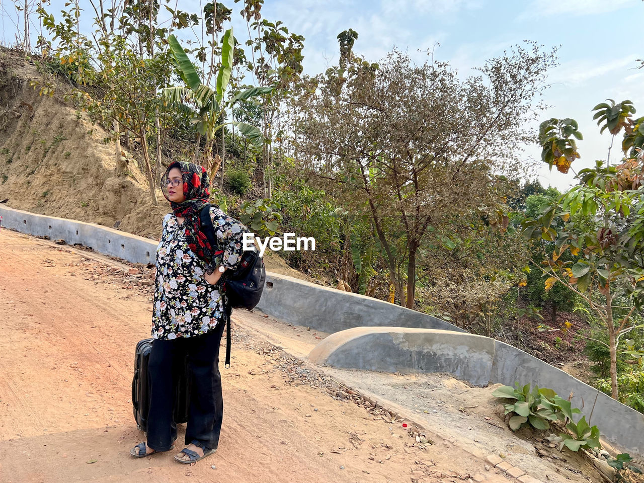 nature, full length, plant, adult, tree, one person, leisure activity, lifestyles, day, outdoors, road, men, women, clothing, land, sky, travel, sunlight, walking, young adult, casual clothing, standing, person, traditional clothing, footpath