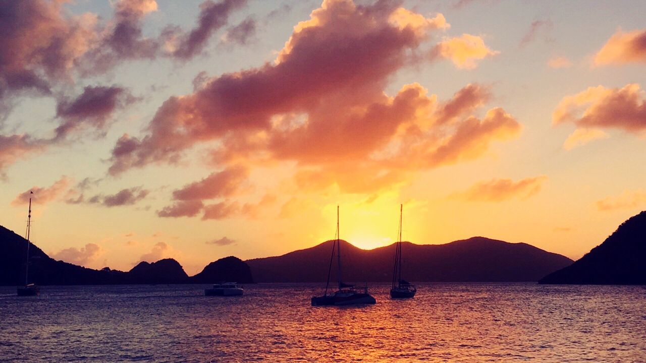 Scenic view of sea against cloudy sky during sunset