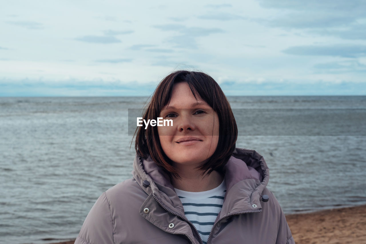 Portrait of a happy woman on the beach in cold weather. the concept of mental health