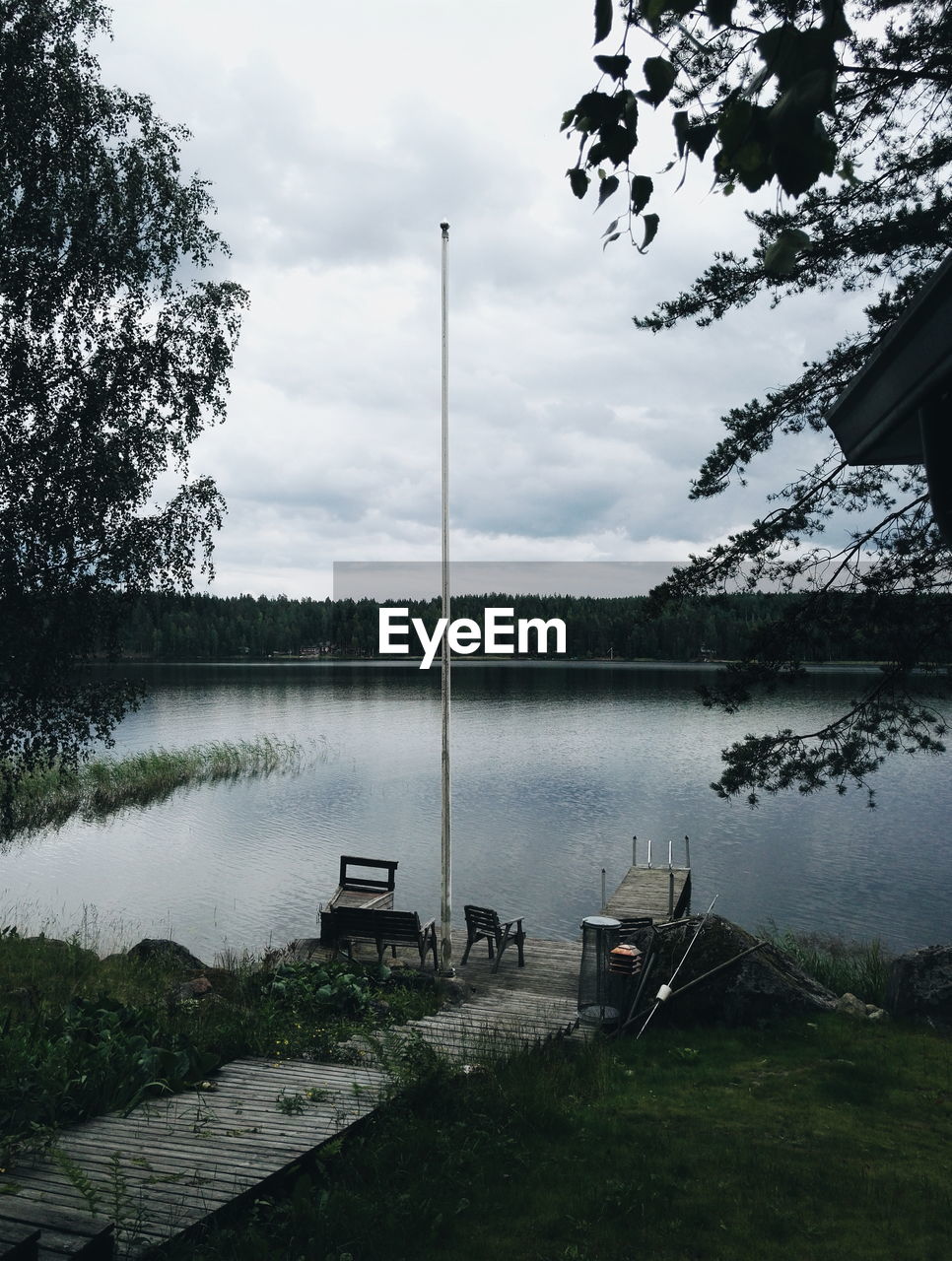 High angle view of empty bench and chair by lake