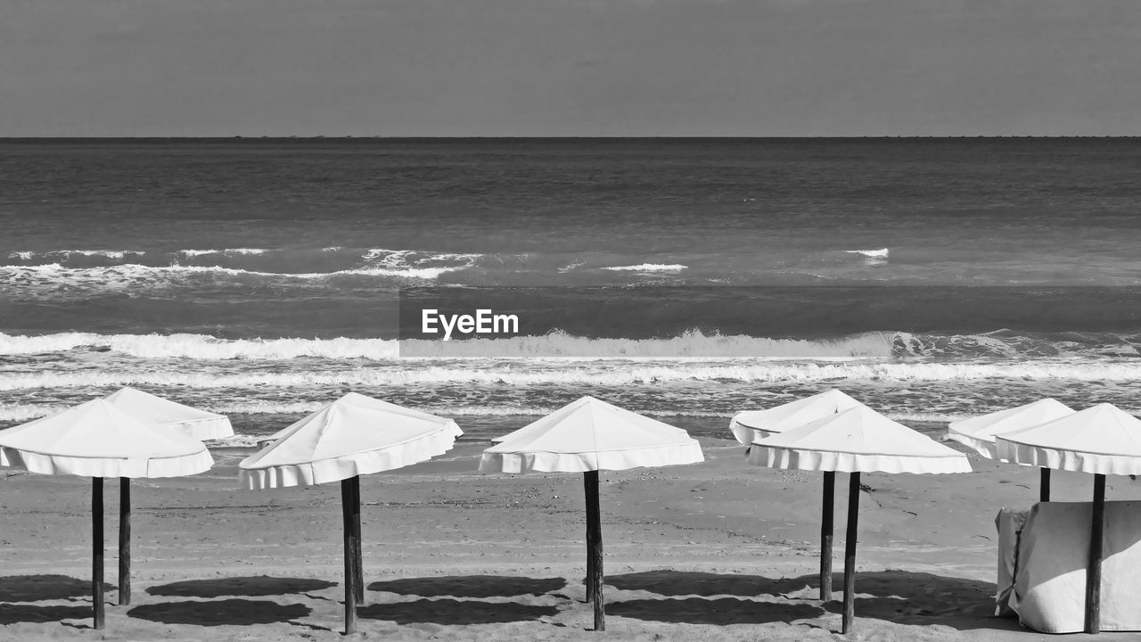 CHAIRS ON BEACH AGAINST SKY