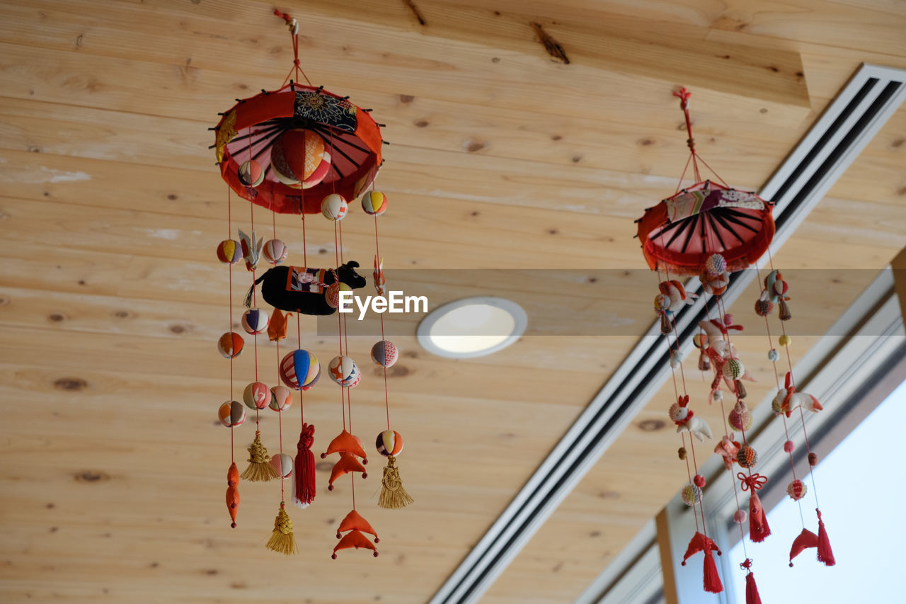 LOW ANGLE VIEW OF ILLUMINATED LANTERNS HANGING FROM CEILING