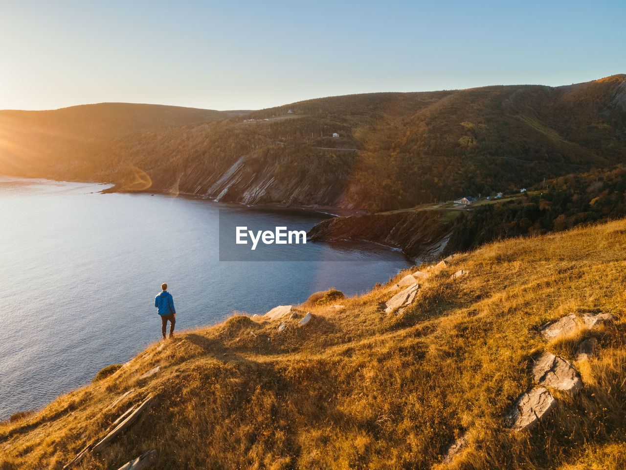 Rear view of man looking at mountains against sky