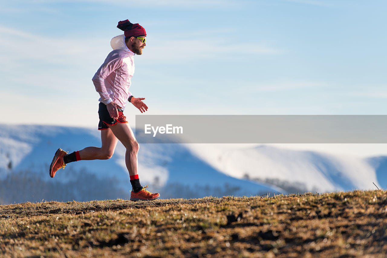 Mountain race. training of an athlete between meadows and snow