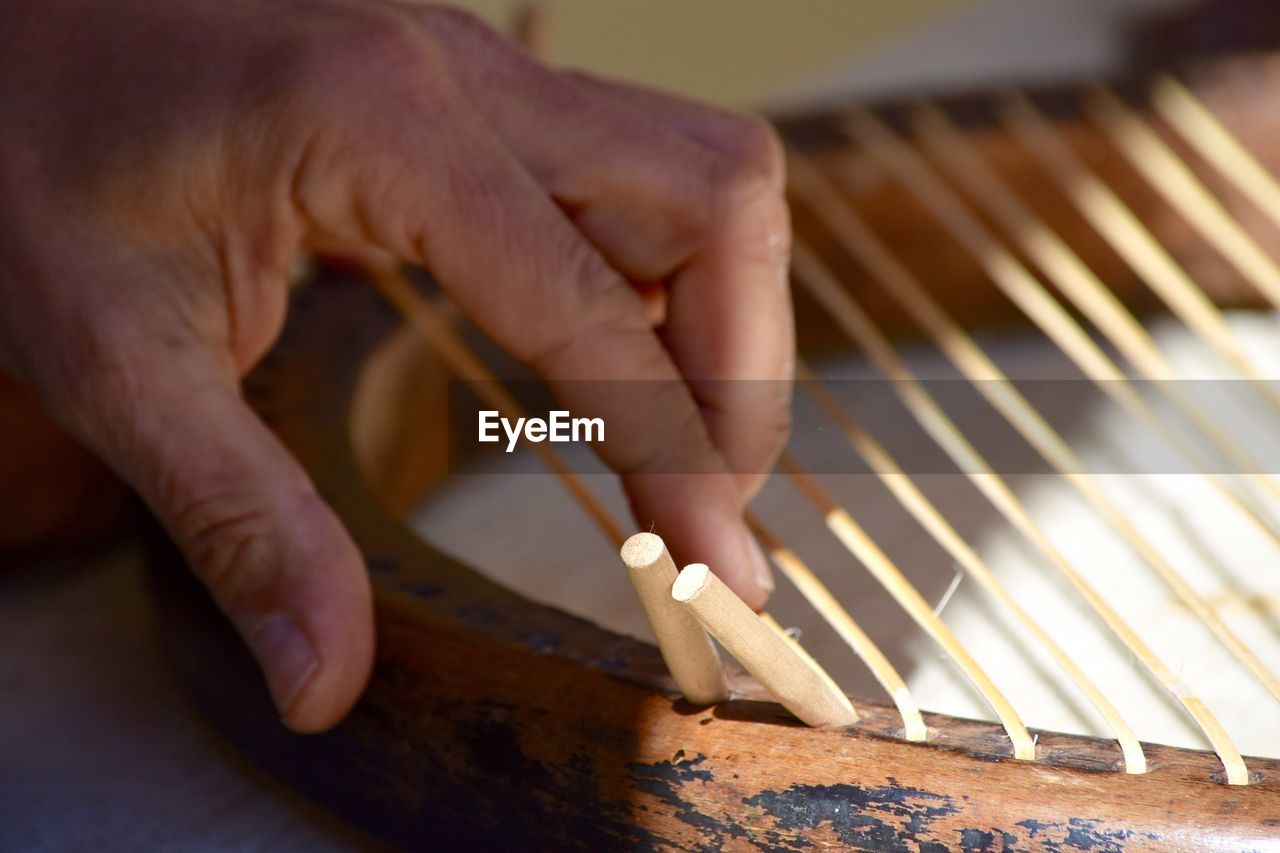 Cropped image of artisan hand touching wooden chair