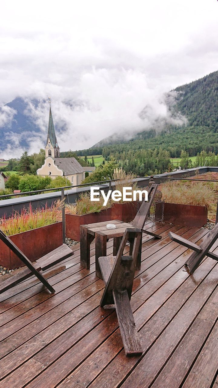 HIGH ANGLE VIEW OF EMPTY CHAIRS BY BUILDINGS AGAINST SKY