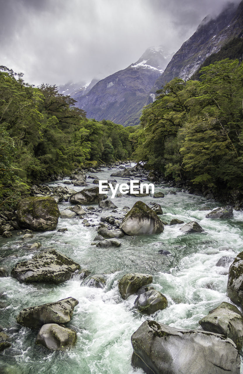 SCENIC VIEW OF WATERFALL AGAINST SKY