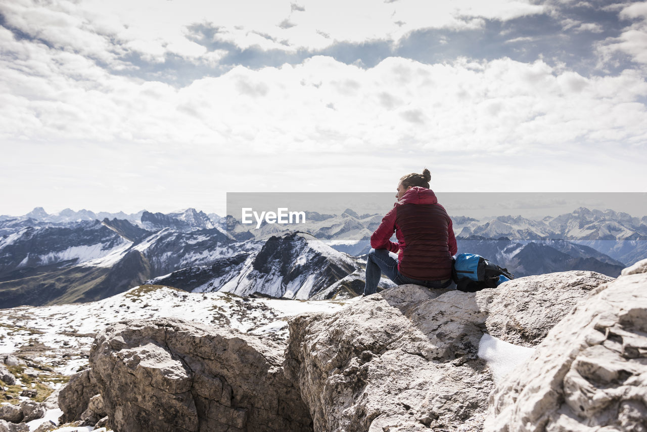 Germany, bavaria, oberstdorf, hiker sitting in alpine scenery