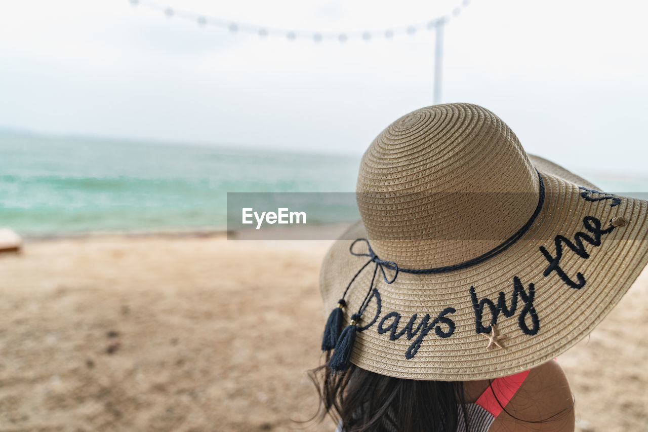 REAR VIEW OF HAT ON BEACH