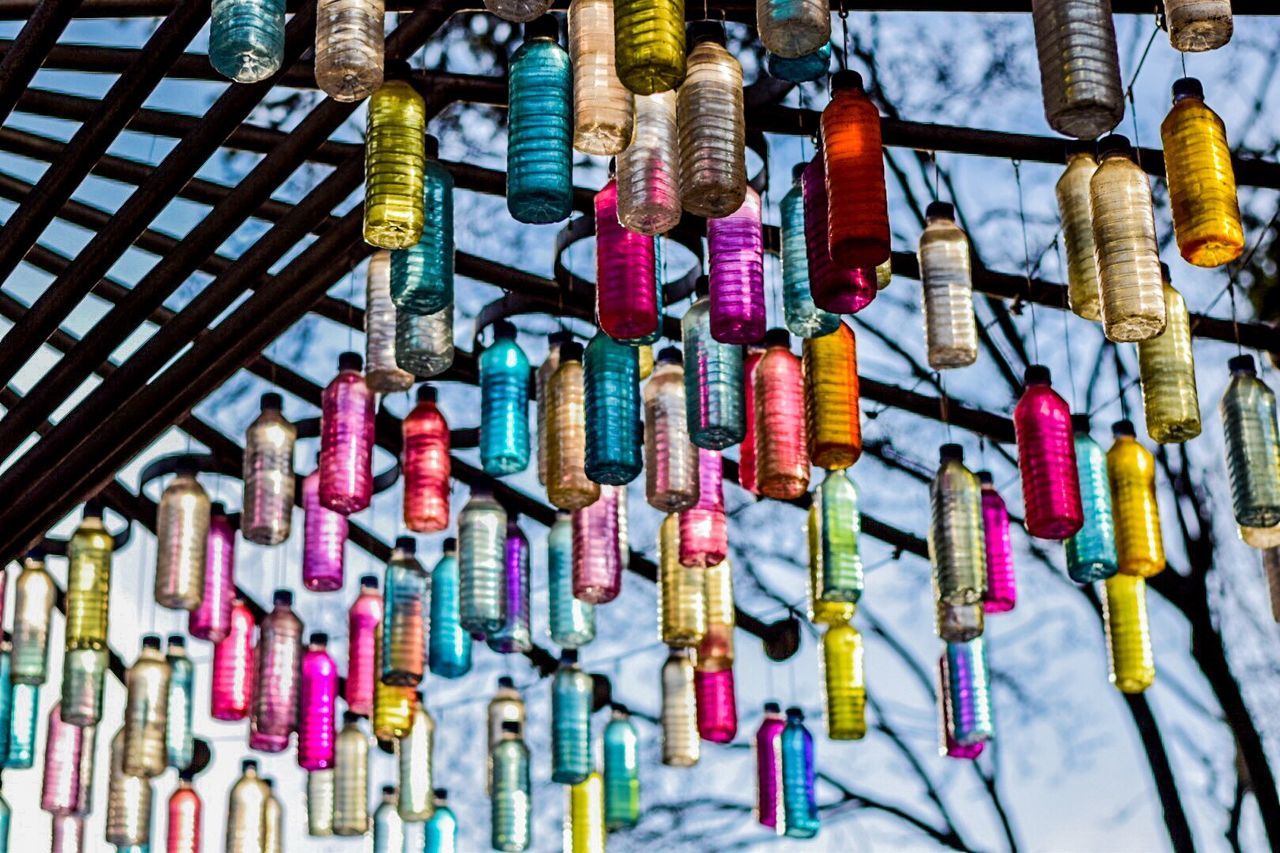 Low angle view of colorful bottles hanging on roof