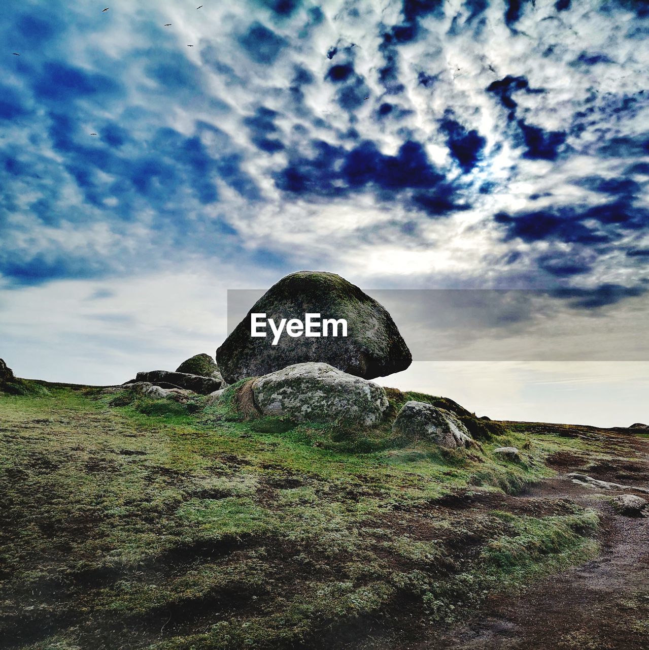 VIEW OF ROCKS ON FIELD AGAINST SKY