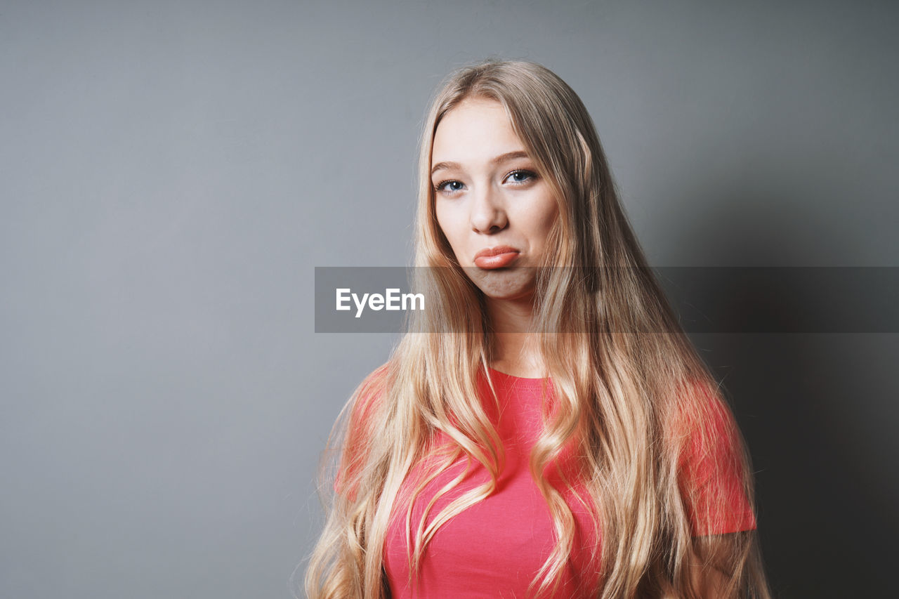 Portrait of teenage girl against gray background