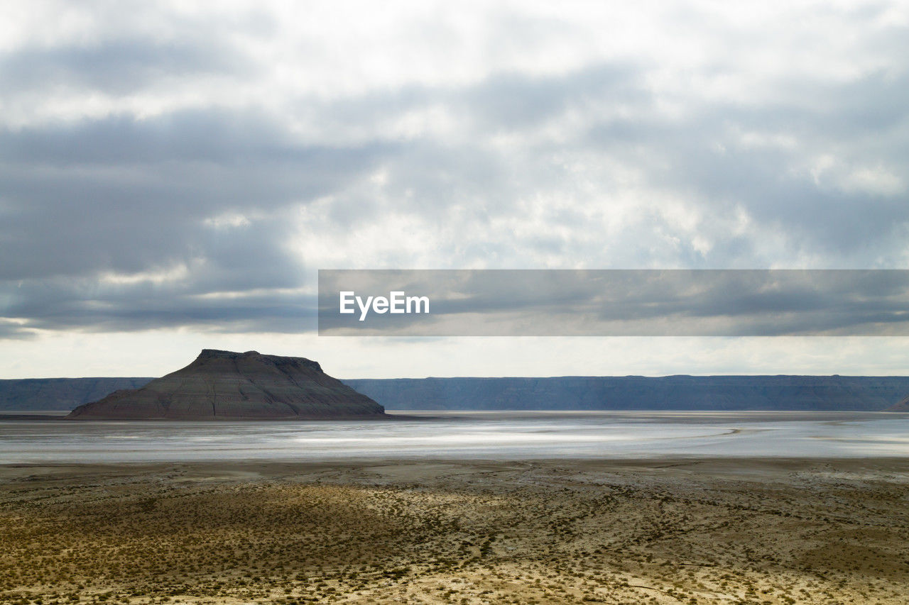 scenic view of beach against cloudy sky