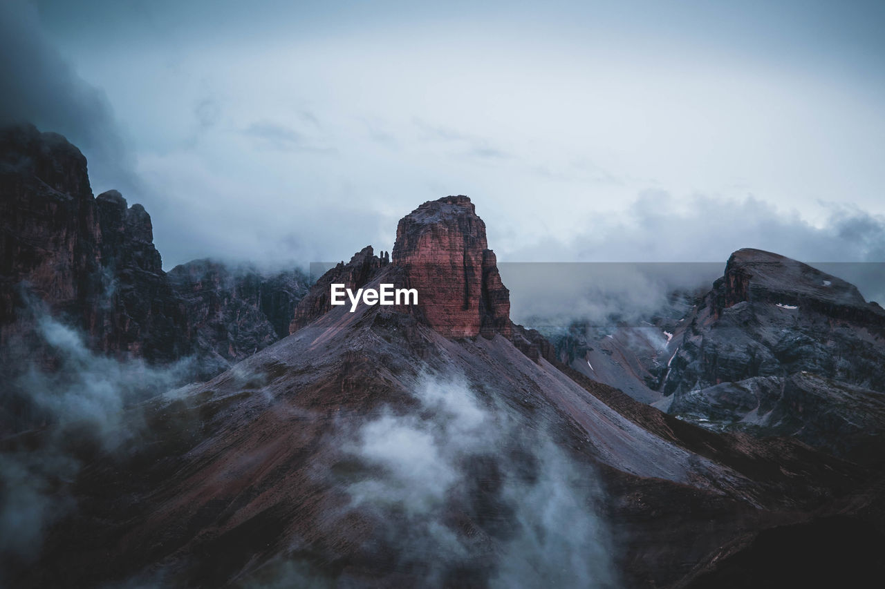 Scenic view of mountain range against cloudy sky