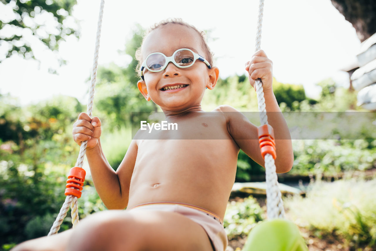 PORTRAIT OF HAPPY GIRL HOLDING SWING