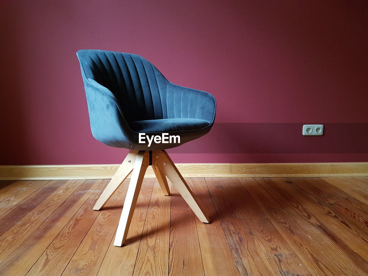 Empty chair on hardwood floor at home