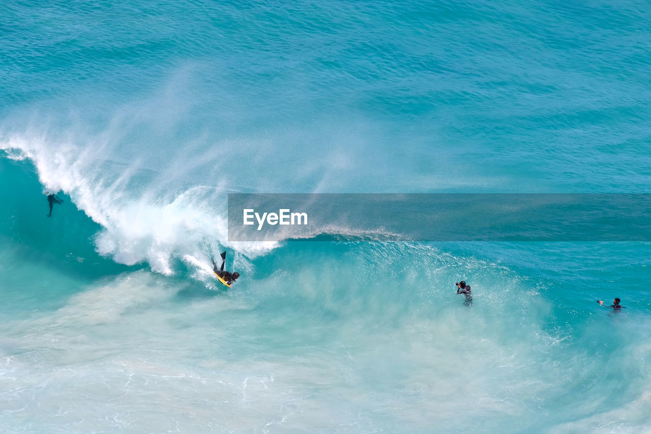 High angle view of people surfing in sea