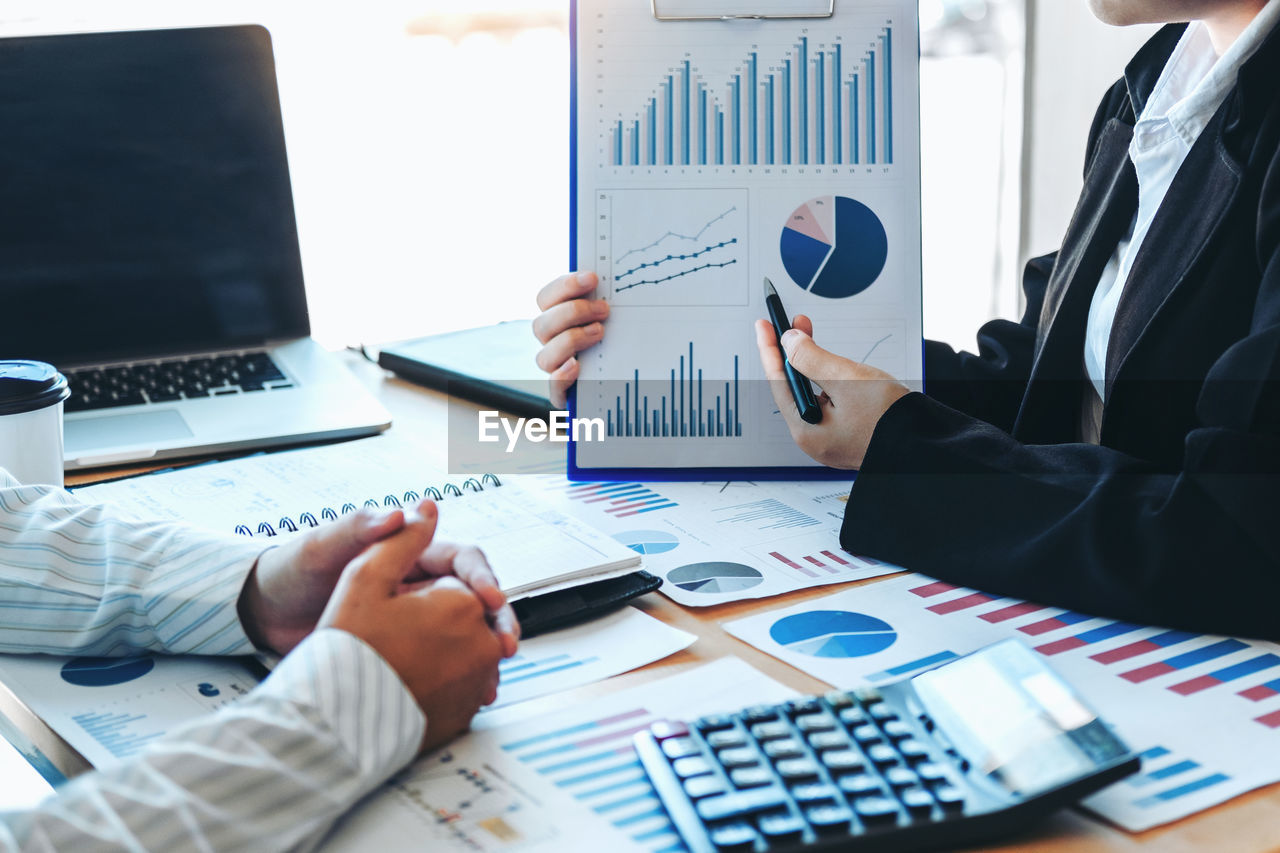 Cropped image of business colleagues working at desk in office