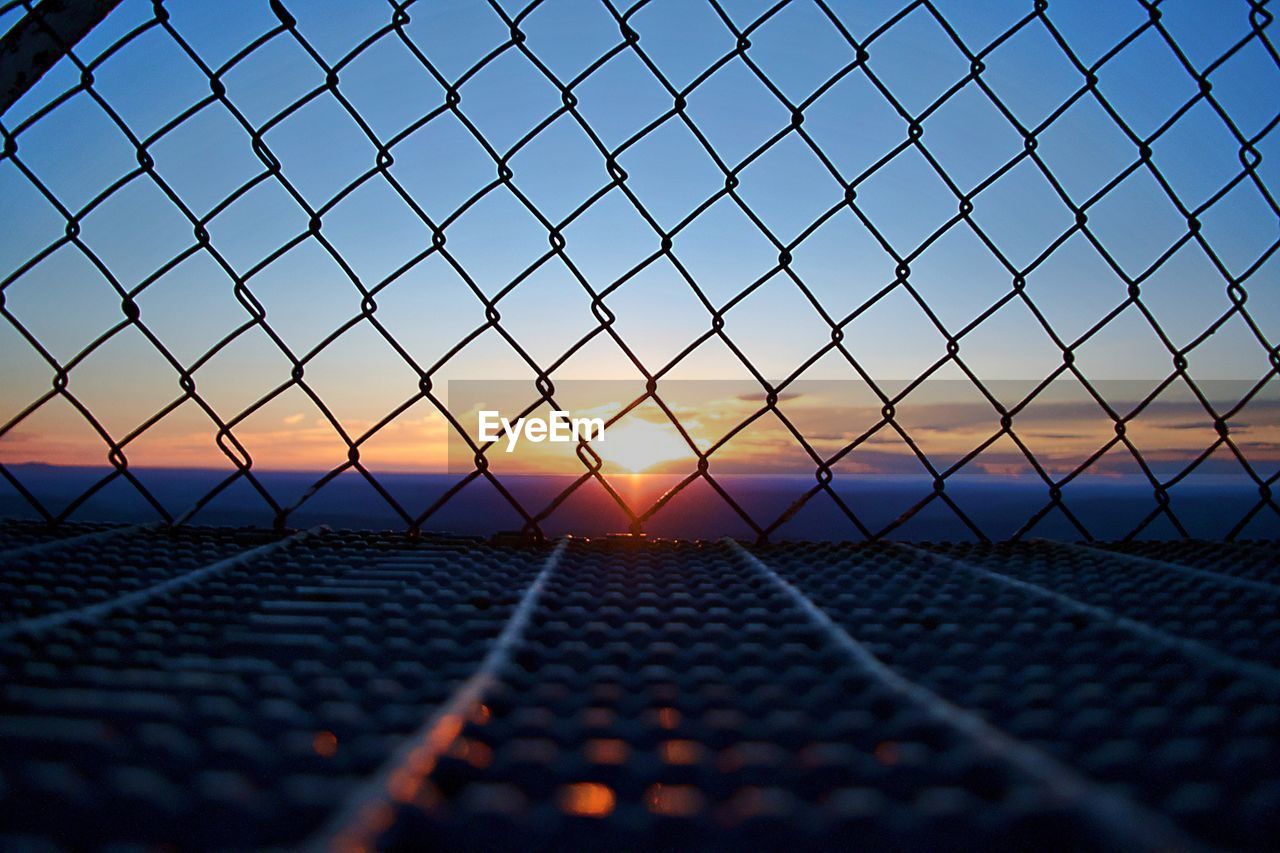 METAL FENCE AGAINST SKY DURING SUNSET