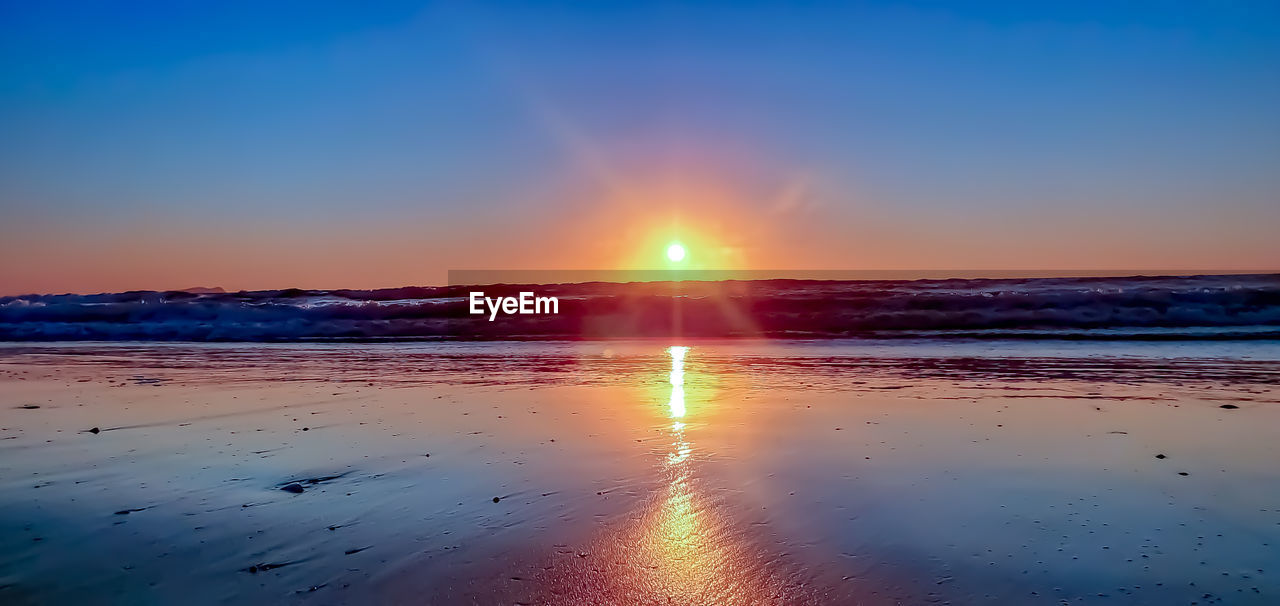 SCENIC VIEW OF SUNSET OVER SEA