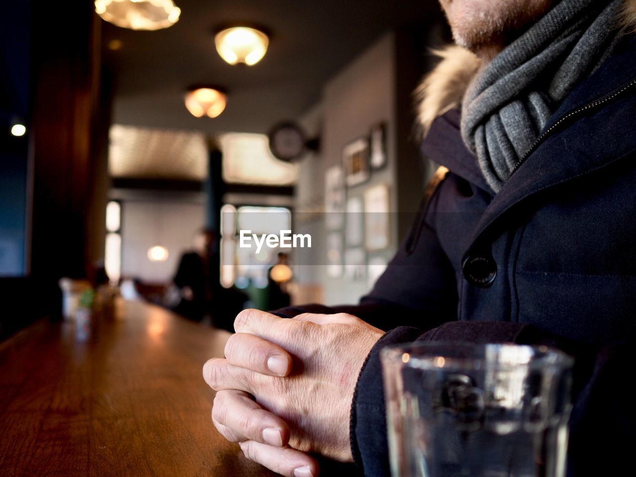 Midsection of man sitting at table in restaurant