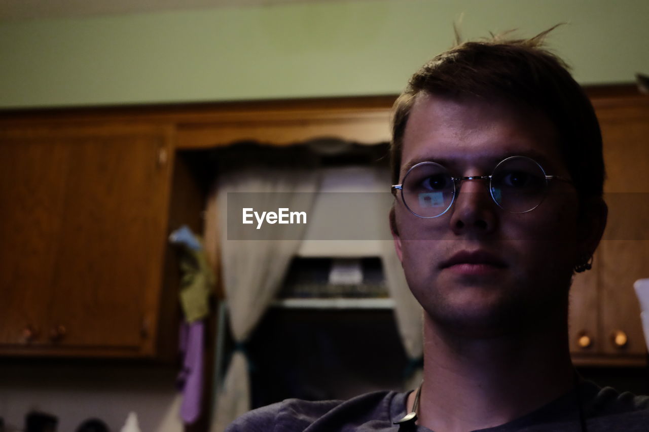 Portrait of man wearing eyeglasses at home