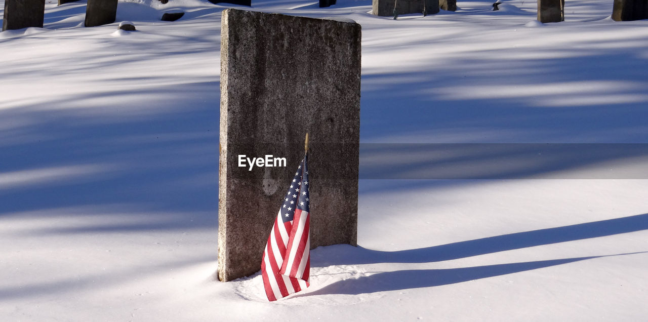 INFORMATION SIGN ON WOODEN POST ON SNOW FIELD