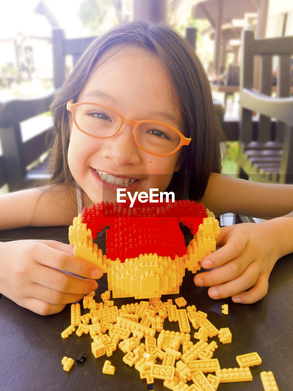 Portrait of happy girl playing with plastic blocks on table