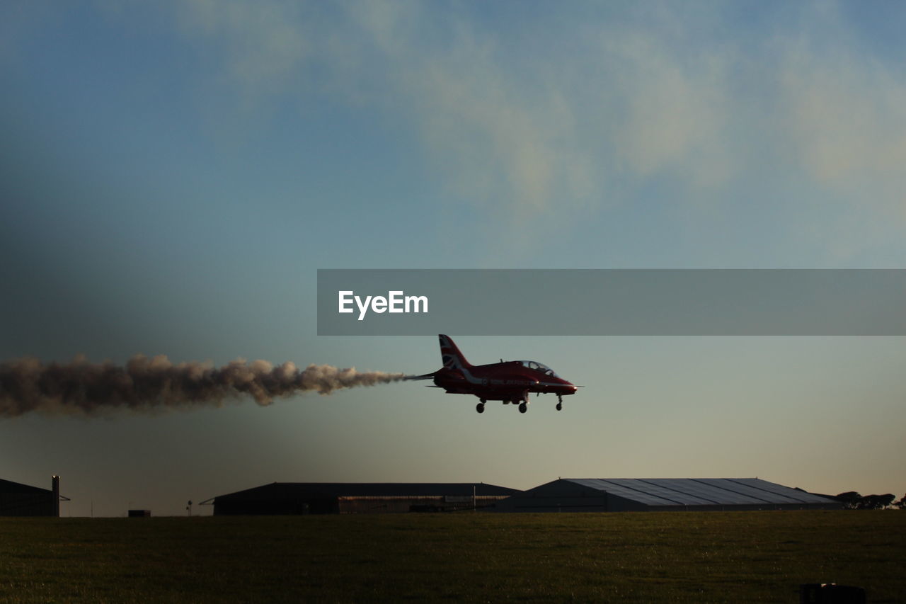 AIRPLANE FLYING ABOVE FIELD