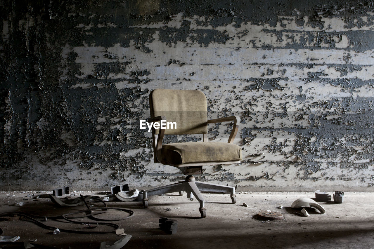 Abandoned chairs in front of wall