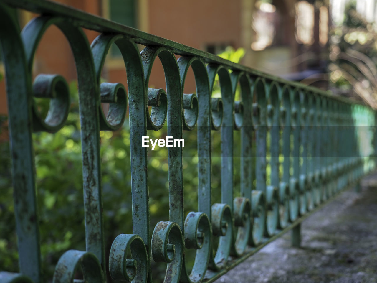 Close-up of metal railing against fence