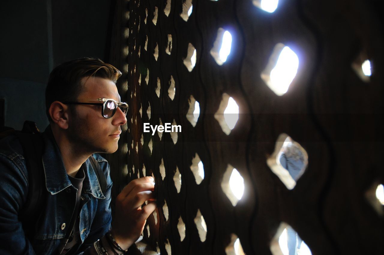 Young man looking through window