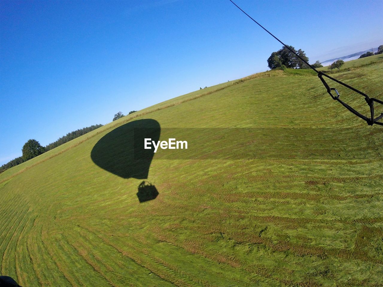 Shadow of hot air balloon on field