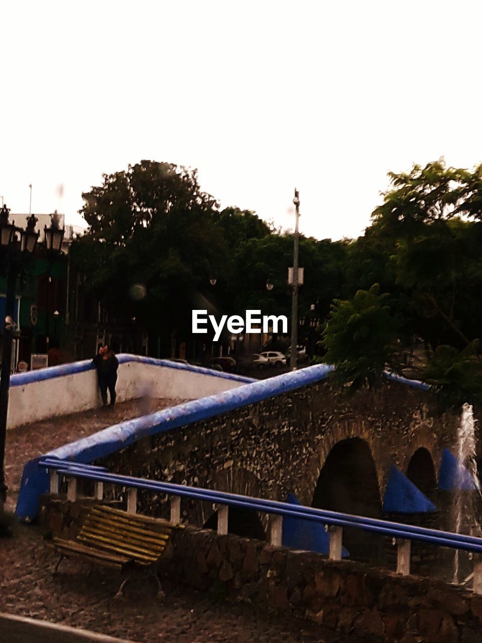 MAN STANDING ON RAILROAD TRACK AGAINST SKY