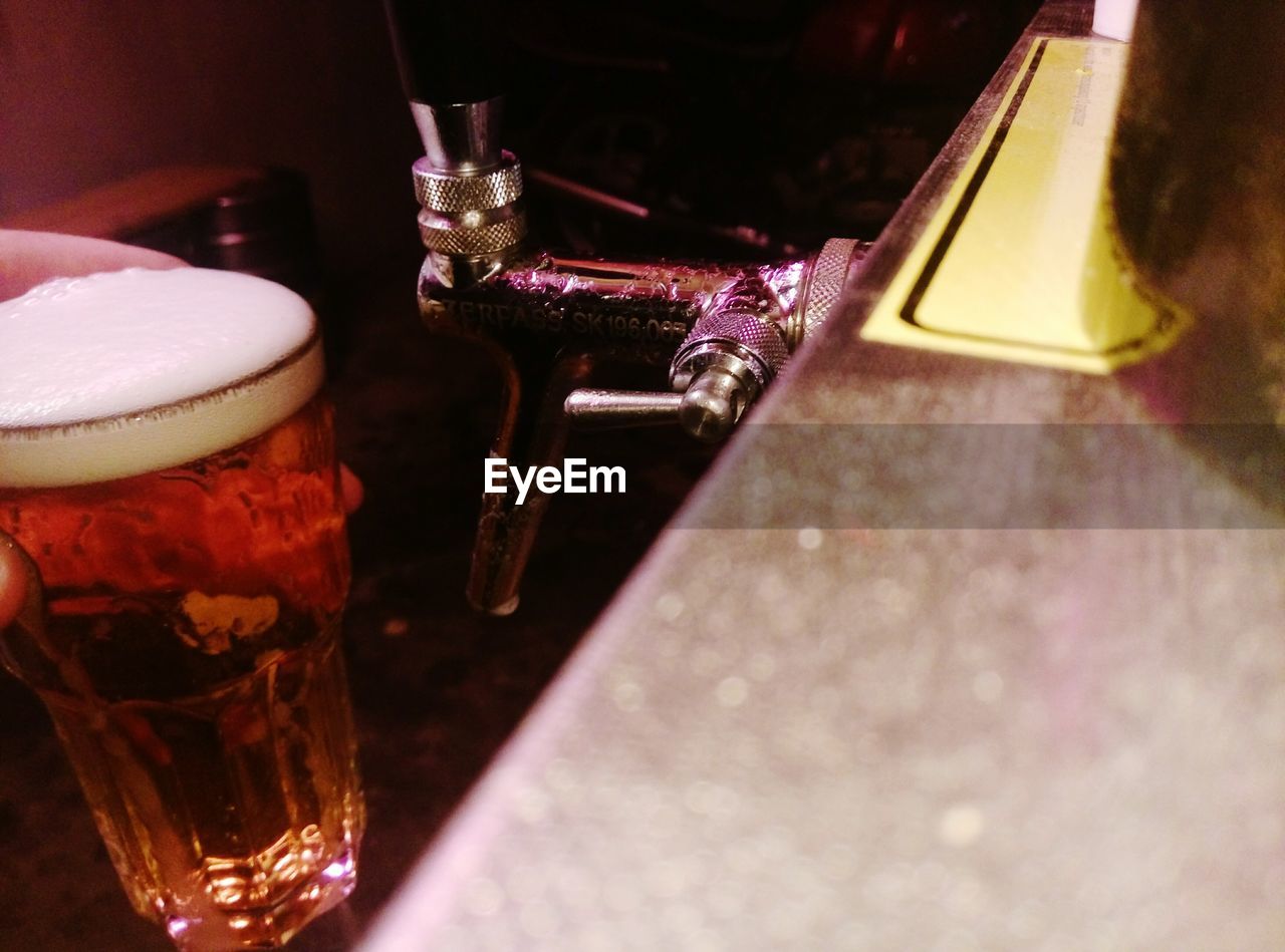 CLOSE-UP OF BEER GLASS ON TABLE AT HOME