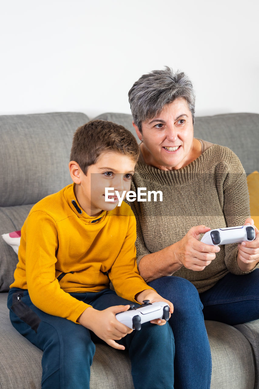 Little kid and his grandmother playing video games