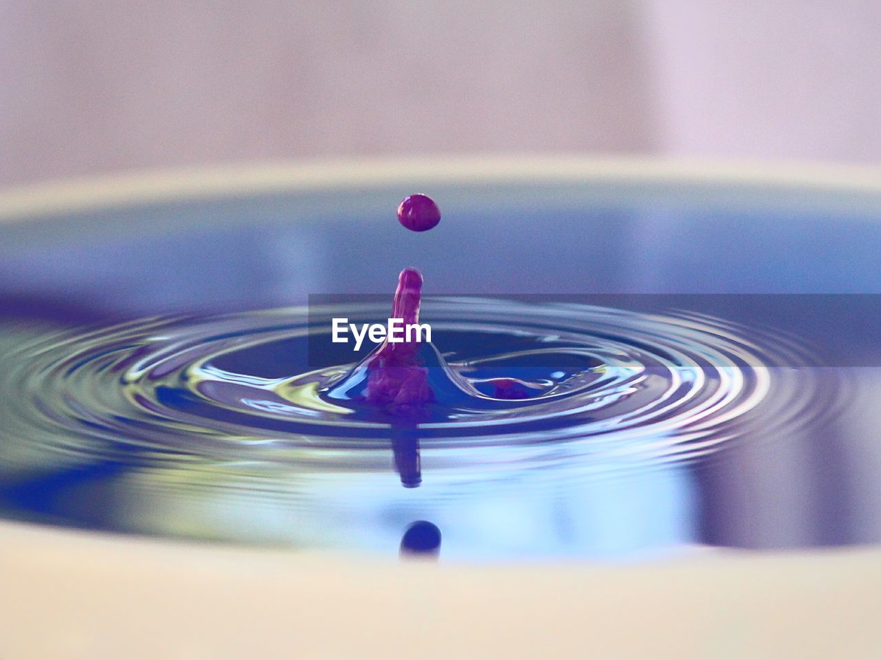 Close-up of drop falling in rippled water